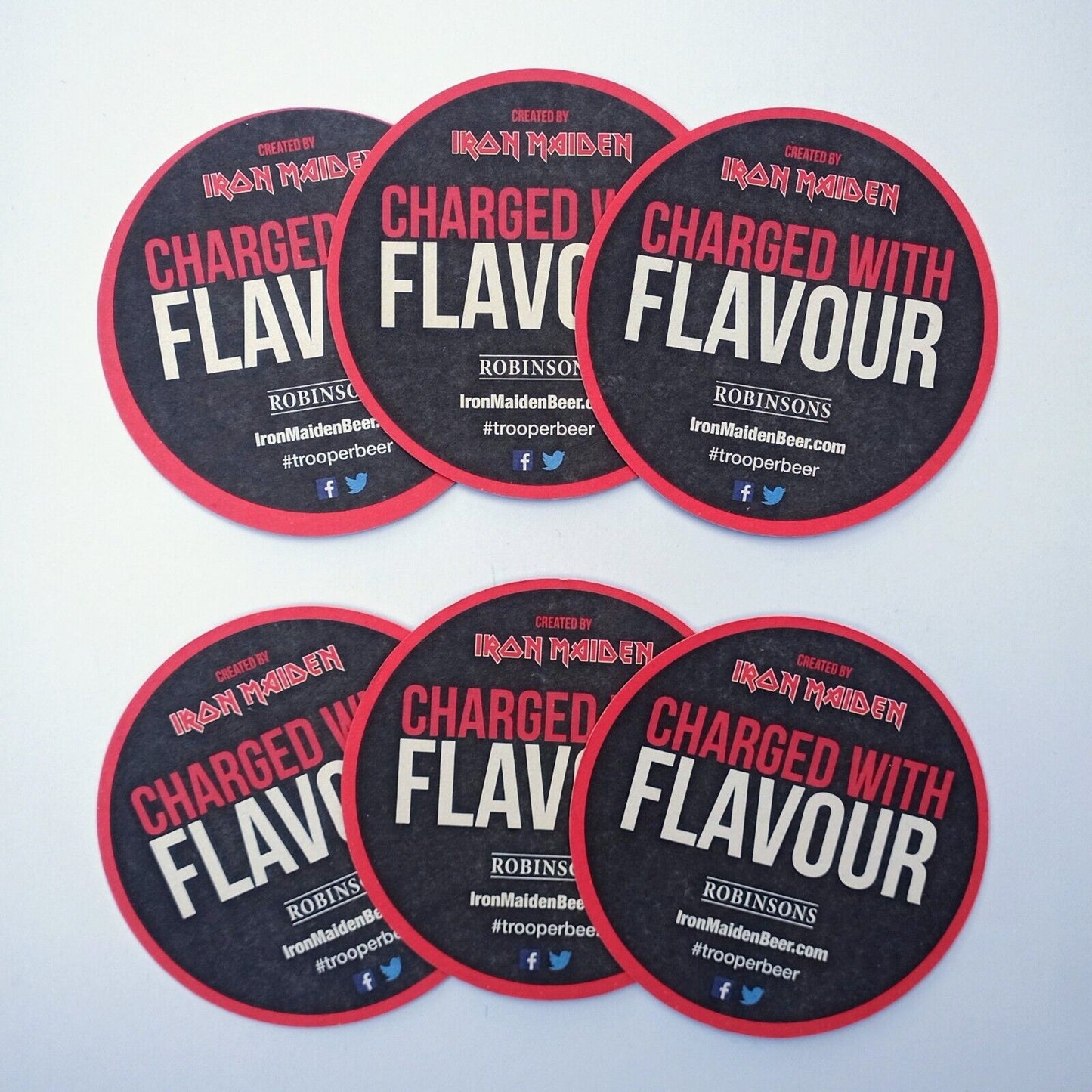 Back view of multiple Iron Maiden Trooper Premium British Beer coasters with ‘Charged with Flavour’ text and Robinsons Brewery branding.